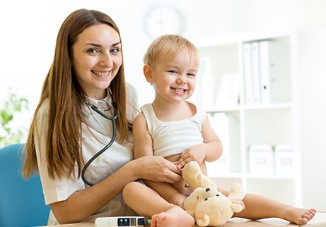 Smiling female doctor holding smiling child